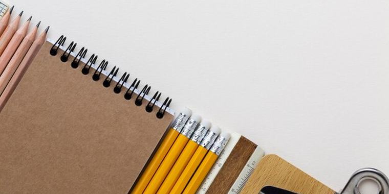 Notebooks, pencils and a stapler on a desk