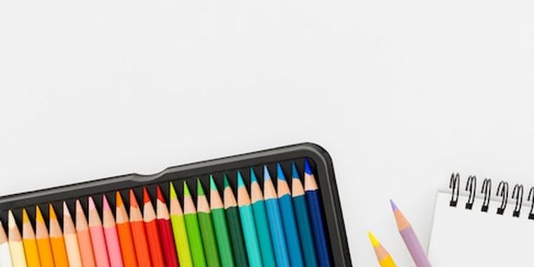 A tin of colouring pencils beside a notepad